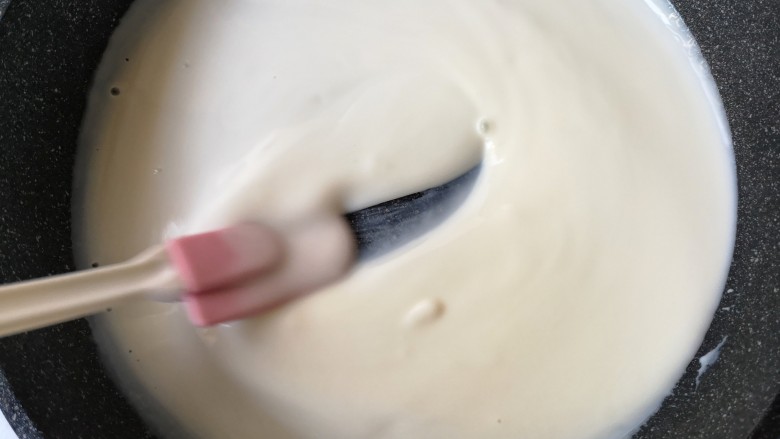 木瓜奶冻,锅中牛奶在小火加热状态下会慢慢凝固。