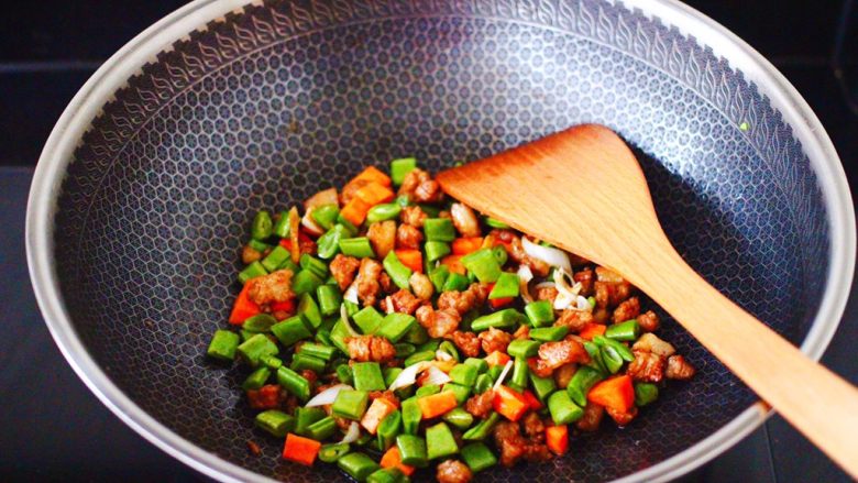 芸豆海虾打卤面,这个时候加入芸豆和胡萝卜丁，大火继续翻炒至芸豆和胡萝卜丁断生变色。