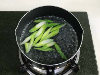 南瓜香肠芦笋意面,锅中倒入适量清水煮沸，放入芦笋，加少许盐煮约1分钟，捞出备用。