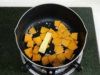 南瓜香肠芦笋意面,开火，锅中倒入食用油，加入蒜蓉爆香，接着加南瓜翻炒，加黄油。
