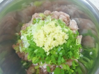 槐花大肉馅饺子,将切碎的小葱和姜末放在肉馅上。