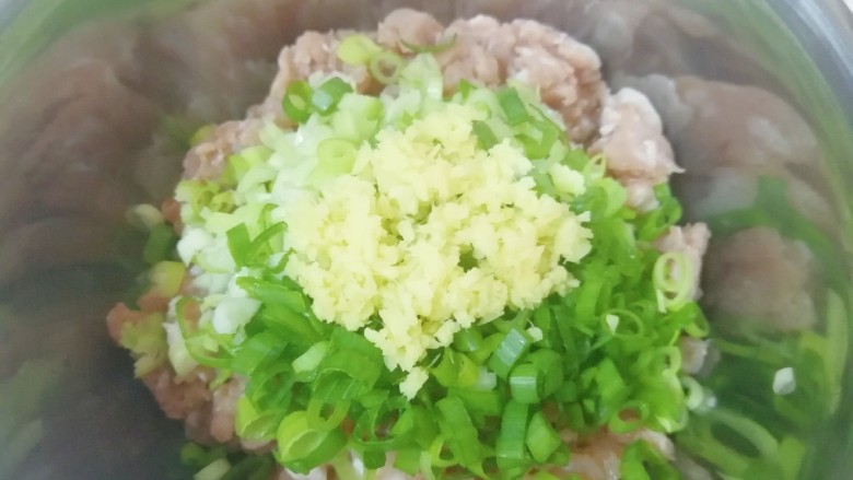 槐花大肉馅饺子,将切碎的小葱和姜末放在肉馅上。