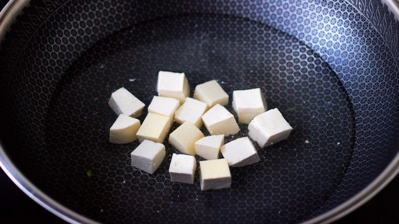丝瓜花蛤炖豆腐,锅中倒入适量的清水，加入少许盐，把豆腐进行焯水，焯一分钟左右即可捞出沥干水分。