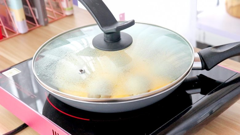 蛋抱米饭团子,盖锅盖，继续小火焖煎至蛋液熟透