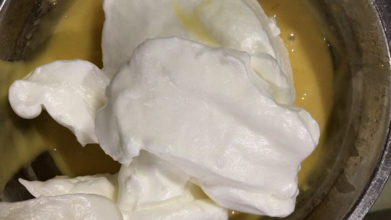 十寸戚风蛋糕（不开裂）,在蛋白霜里加入三分之一蛋白霜，用硅胶刀翻拌均匀，用J或Z字型翻拌均匀，不要画圈搅拌以免蛋白消泡。