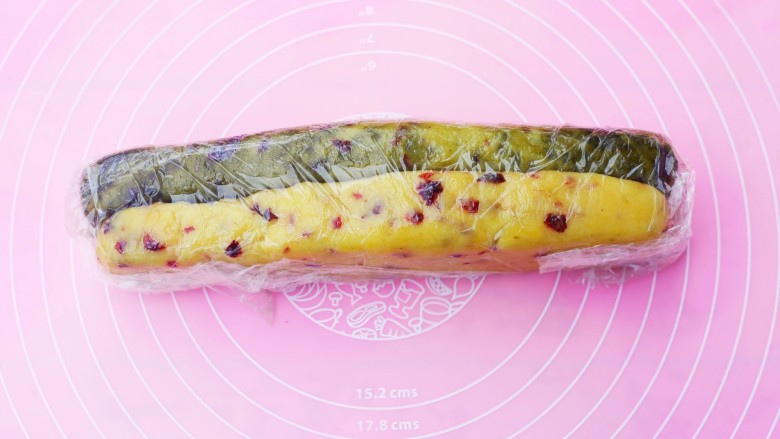 双色蔓越莓饼干,包入保鲜膜中，整理成型，放冰箱冷冻1小时。