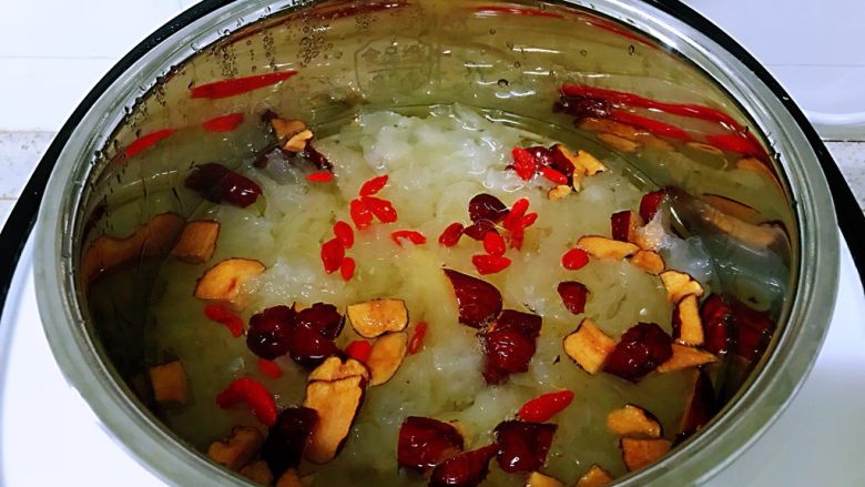 银耳红枣羹,当养生煲上面的时间显示为10分钟的时候，打开盖子放入红枣和枸杞，拿配的专用勺子搅一搅，盖上盖子继续熬煮。