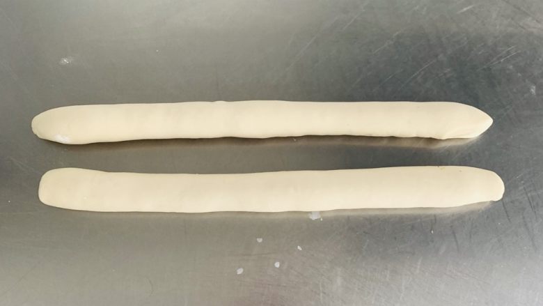 猪肉茴香馅儿饺子🥟,揉均匀的面团平均分成两份，取其中的一份揉搓成长条形。