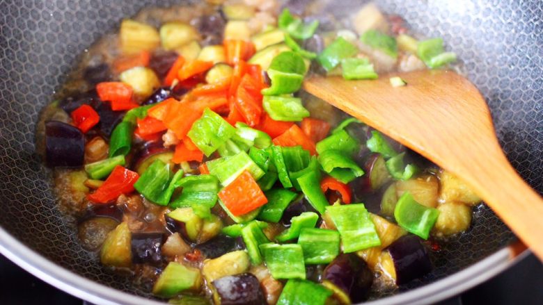 茄丁双椒炒肉丁,看见锅中汤汁浓稠时，加入青红椒丁。