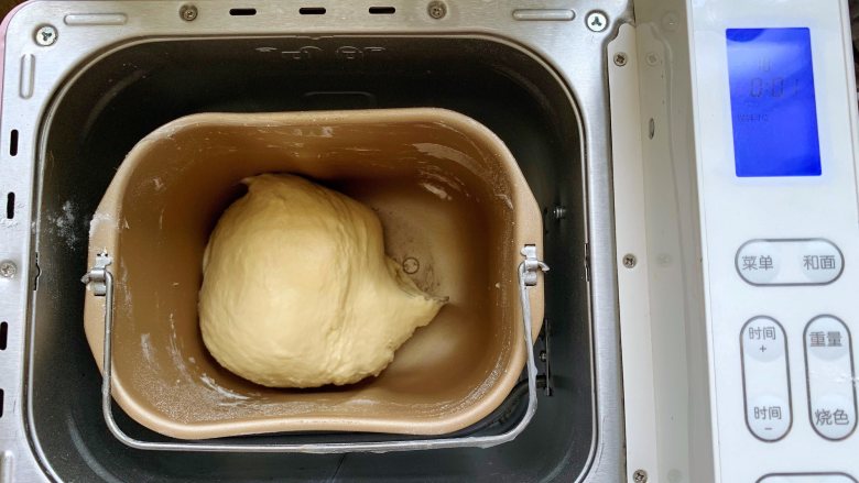 发面豆沙油酥饼,首先将油皮面团的所有食材放入面包机里，揉成光滑的面团，因为面粉的吸水性不一样，水最好分次加入面粉里，根据实际情况增减清水的用量。