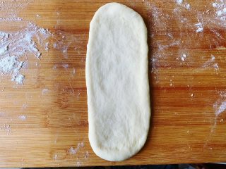 发面豆沙油酥饼,然后用擀面棍擀成牛舌状。