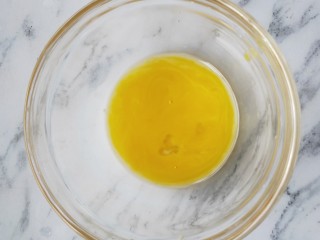 欧式风情下午茶|加了苹果的蛋挞,另取一个碗，把准备好的鸡蛋蛋黄磕入碗中，用筷子搅散备用。