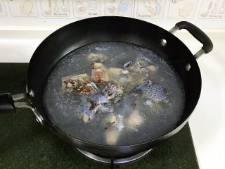 菌菇山药乌鸡汤,锅中倒入适量的清水，乌鸡肉洗净冷水下锅，放入花椒和料酒，开火煮沸后即可捞出。