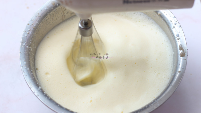 提拉米苏,煮沸的牛奶缓慢呈细线状加入蛋黄中，同时用电动打蛋器高速搅打，打发至蛋黄液逐渐膨胀变白