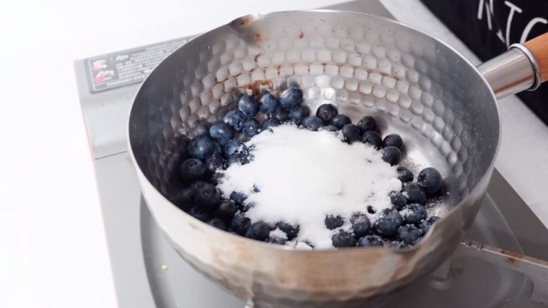 梦幻蓝莓冰饮,将蓝莓倒入平底锅里，加白砂糖、加水、开火熬煮