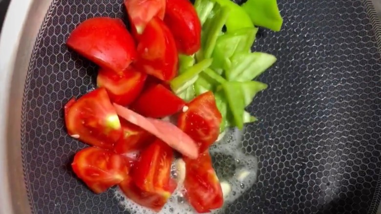 西红柿🍅炒花菜,放入西红柿，火腿，辣椒翻炒