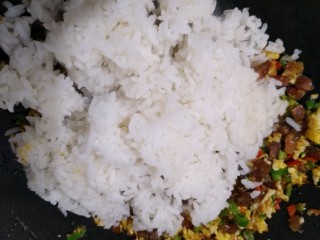 香肠鸡蛋炒饭,倒入米饭一起翻炒，把米饭炒散，看到米饭在锅里跳动
