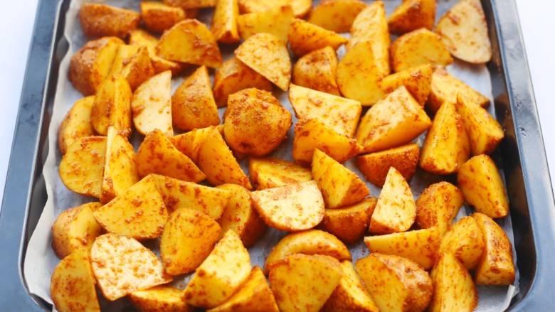 好吃到吮指的烤薯角,处理好的土豆放入铺好油纸的烤盘中。