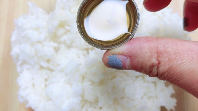 西兰花芝士饭团,在米饭上淋一些寿司醋，均匀的洒在米饭上。