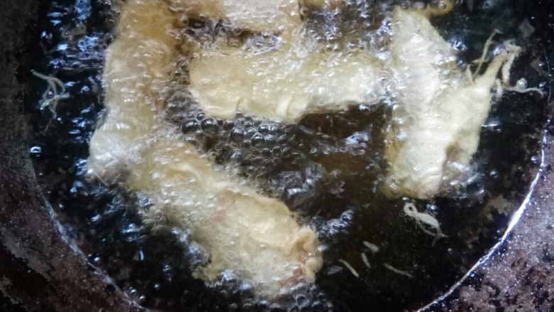 苏杭美食一梅香带鱼,放入油锅中炸制。