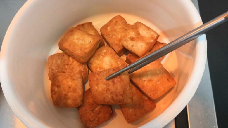 豆腐焖茄子,豆腐煎至，两面金黄后，把豆腐用筷子夹出，放入小一点的焖锅中，备用