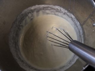 心型轻奶酪蛋糕,另取一个盆，盆里放奶酪加牛奶和淡奶油，放在开小火的热水锅里隔水加热，搅拌融化。