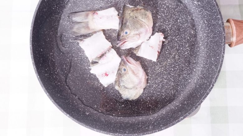 柠檬酸汤鲈鱼,热锅倒油，将鱼头鱼骨煎至焦黄