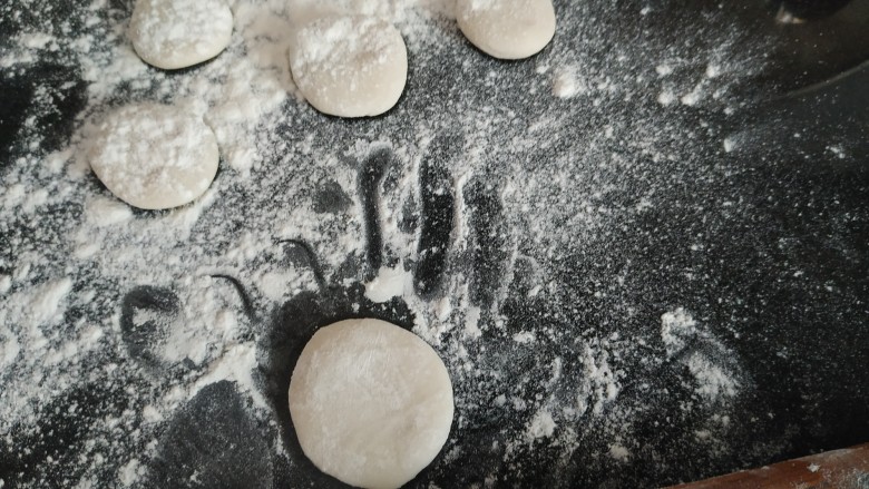 咸蛋黄糯米烧麦,把每个小剂子揉圆按扁，撒适量手粉防止粘连；