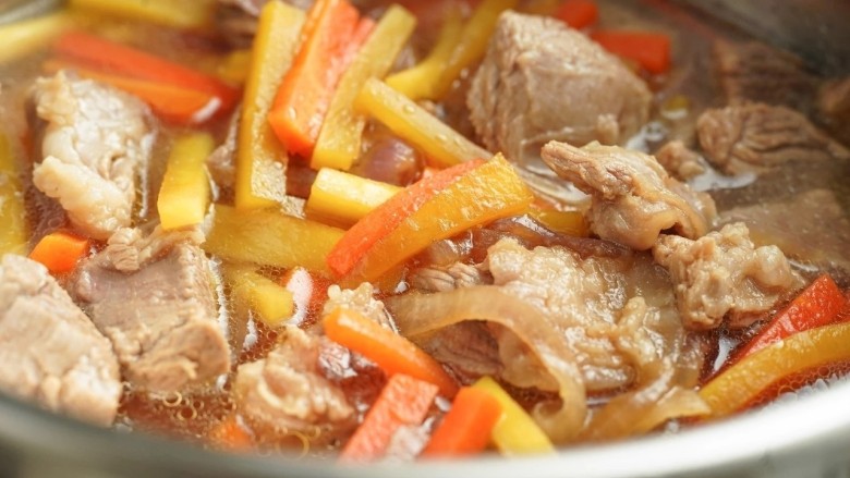 新疆特色手抓饭,倒入炒好的洋葱、胡萝卜、羊肉和汤