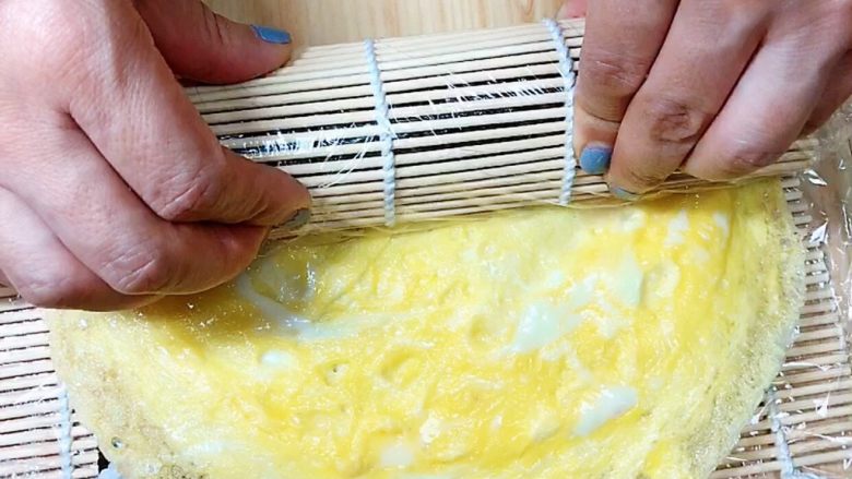 金枪鱼胚芽米寿司 | 便当,从顶部开始卷起，逐渐取出帘子，往前卷起。将最后多余的蛋卷剪掉即可收边。