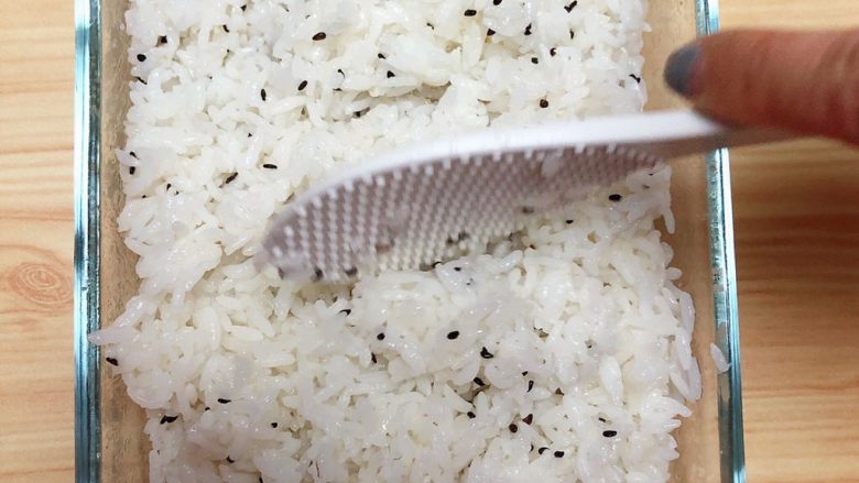 金枪鱼胚芽米寿司 | 便当,用勺将米饭与醋拌均匀，竖着翻拌，避免米粒拌碎了。
