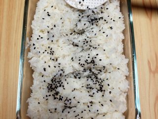 金枪鱼胚芽米寿司 | 便当,将米饭盛出来放入碗中，撒上一些黑芝麻。