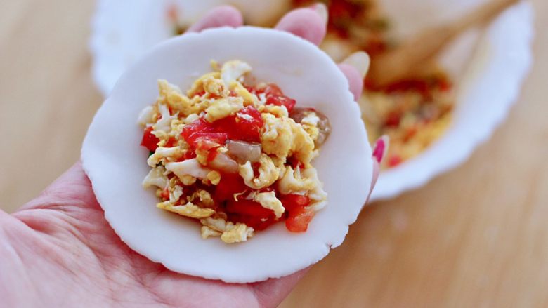 番茄虾仁鸡蛋水晶蒸饺,擀好的面皮上，放入适量的馅料。