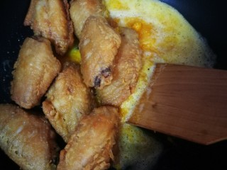 咸蛋黄鸡翅,鸡翅倒入锅中翻炒均匀，待蛋黄全部裹在鸡翅上，即可