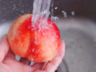 水蜜桃车厘子奶昔,把水蜜桃先用刷子刷去表面上的桃毛，然后用自来水反复冲洗干净，对桃毛过敏的亲们，一定要带上手套操作喲。