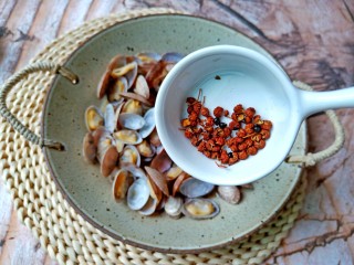 葱香油爆花蛤,把花蛤放入碗里，加上花椒粒。