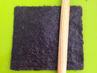 自制海苔片,取一片紫菜盖在芝麻上面，用擀面杖压实即可