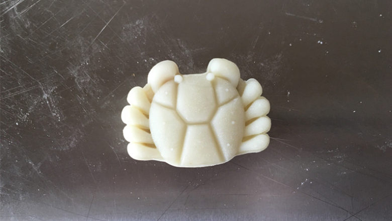 莲蓉蜜豆冰皮月饼,模具内撒一点手粉，将月饼压出形状即可。