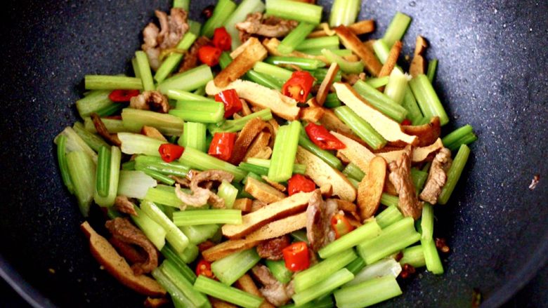 豆干肉片芹菜小炒,大火快速翻炒至芹菜和红尖椒变色断生即可。
