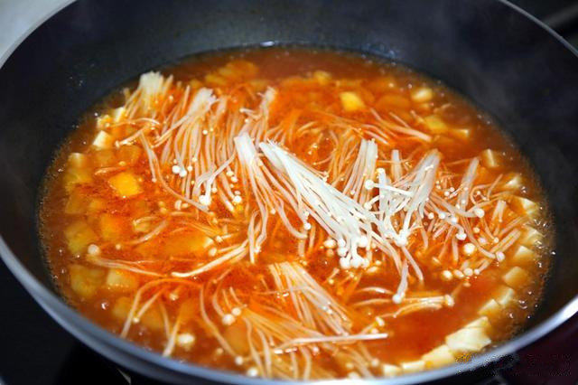 番茄豆腐汤,把金针菇放入锅中，再放入1勺盐调味；