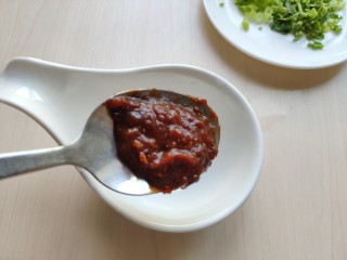 铁板豆腐,用一小碗调一个酱料。先加入一勺蒜蓉辣酱，没有可换甜面酱或豆瓣酱。