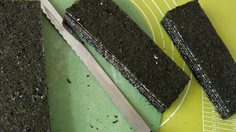 自制海苔片,从烤箱取出烤好的海苔片，用刀切成你喜欢的大小，我用面包刀切割的，做的也比较齐整。
