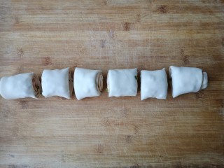腐乳葱香饼,用刀把卷好的圆桶，切成大小均匀的段。