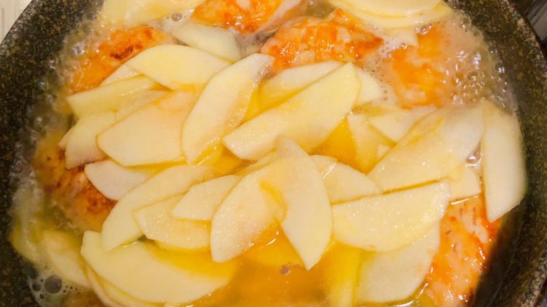 苹果烧鸡翅,鸡中翅煎至两面金黄后放入蜂蜜苹果片在煎至苹果稍微变色就加入150ml的清水。