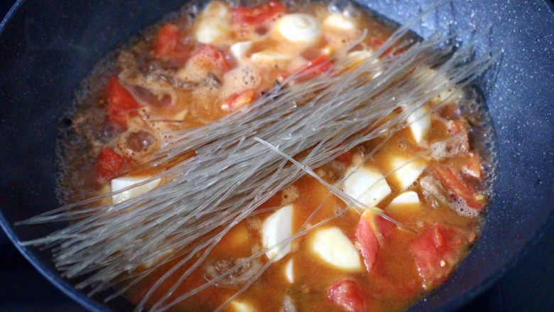 芋头番茄粉条煲,大火烧开后，粉条用清水冲洗干净，放入锅中。