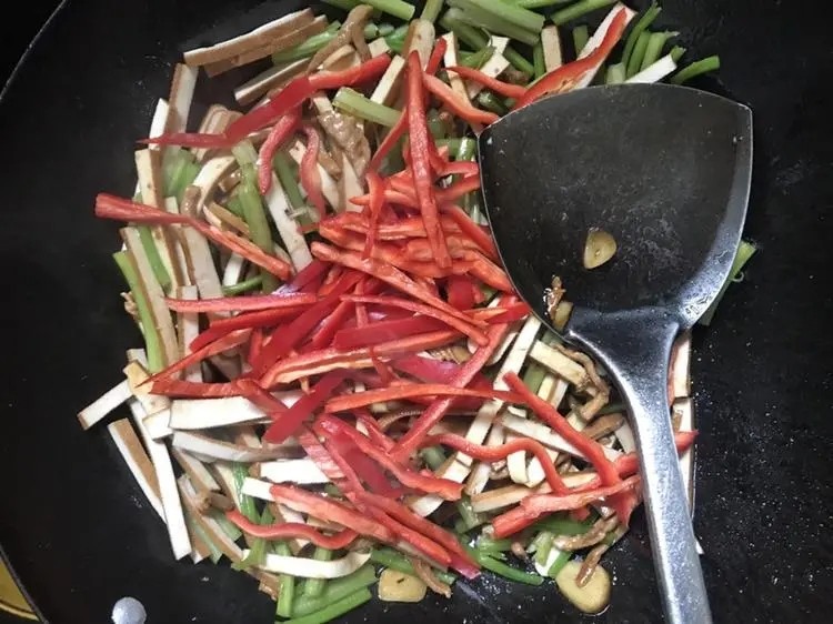 豆干炒芹菜,放入豆干，香芹继续翻炒，炒到香芹微变色，放入辣椒丝翻炒均匀即可出锅。