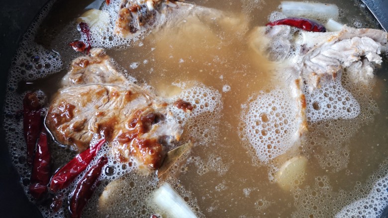 东北酱大骨,把过筛滤好的骨汤倒回锅中。