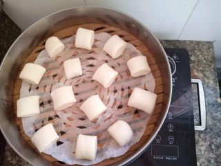 奶香刀切馒头,把切好的馒头胚放进铺了油纸蒸屉里，隔水发酵大约20-25分钟左右