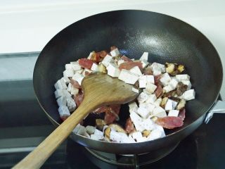 电饭煲美食~香菇腊肠芋头饭,起油锅，倒入香菇、腊肠和芋头