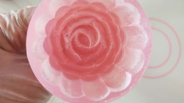 玫瑰栗蓉冰皮月饼,8.包好的面团表面裹上一层薄薄的手粉。模具里面也撒一层手粉后再倒出来。这样脱模比较好脱。
